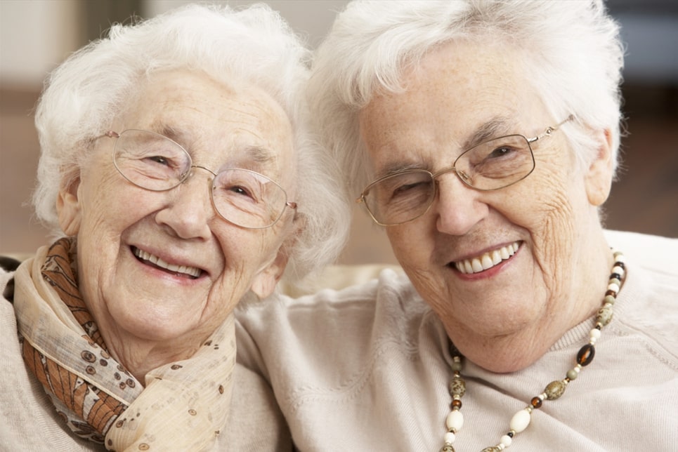 Photo: two elderly women smiling.