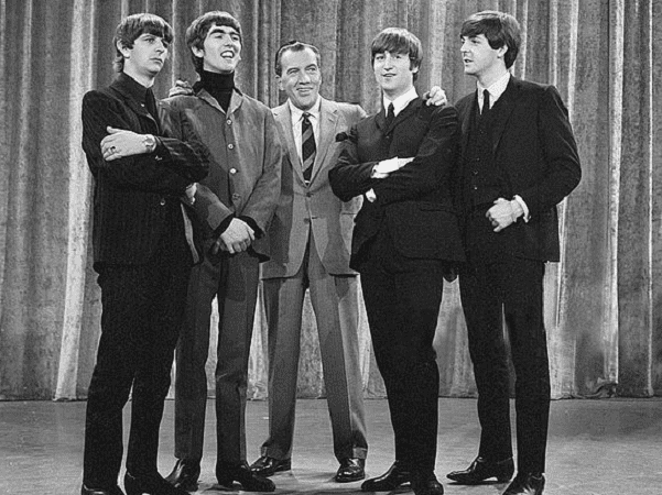 Photo: The Beatles with Ed Sullivan from their first appearance on Sullivan's U.S. variety television program in February 1964. From left: Ringo Starr, George Harrison, Ed Sullivan, John Lennon, Paul McCartney. Credit: CBS Television; Wikimedia Commons.