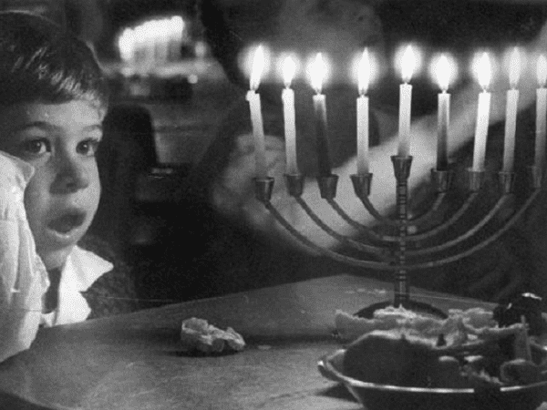 Photo: boy in front of a menorah, c. 1955. Credit: PikiWiki - Israel free image collection project; Wikimedia Commons.
