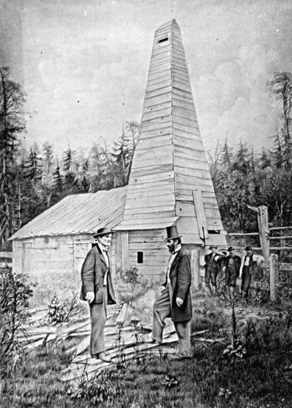 Photo: “Edwin L. Drake, to the right, and the Drake Well in the background, in Titusville, Pennsylvania, where the first commercial well was drilled in 1859 to find oil.” 