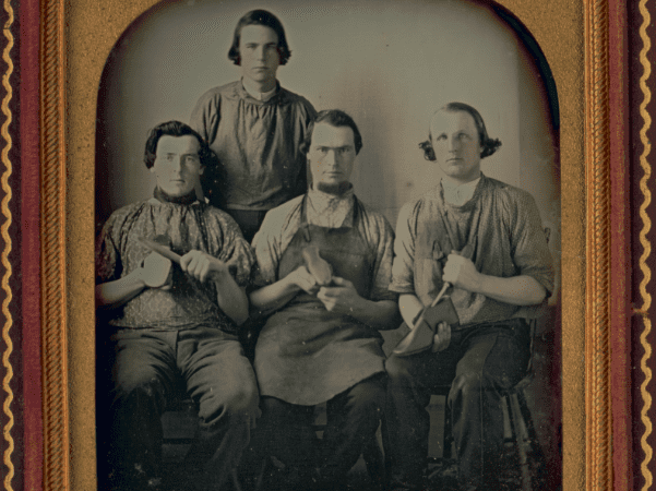 Photo: Occupational group portrait of four shoemakers, one full-length, standing, other three seated, holding shoes and shoe making equipment, c. 1840-1860. Credit: Library of Congress, Prints and Photographs Division.