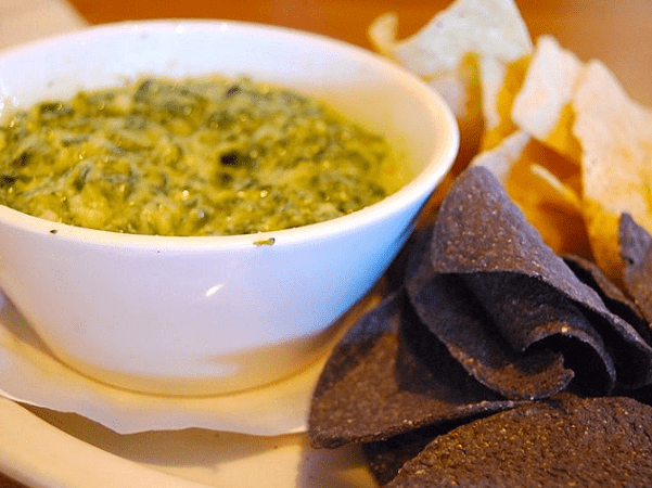 Photo: spinach and artichoke dip with tortilla chips. Credit: Janine; Wikimedia Commons.