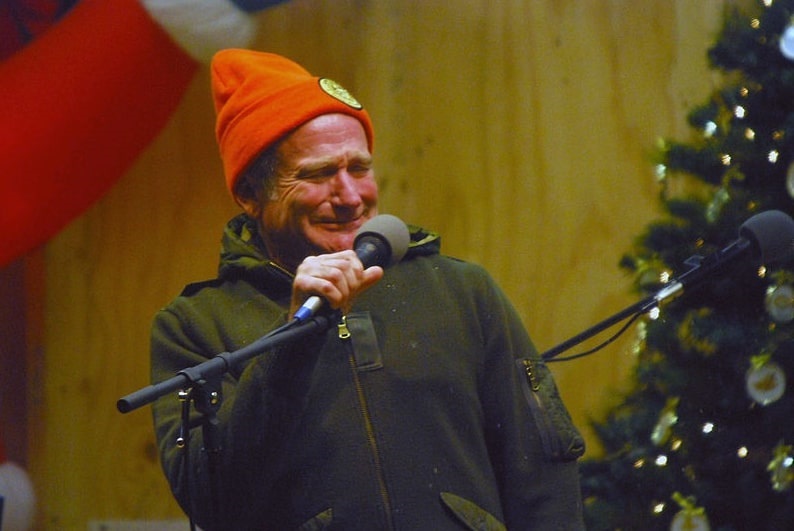 Photo: Robin Williams performs for military men and women as part of a United Service Organization (USO) show at Camp Phoenix, Kubal, Afghanistan, on 20 December 2007. Credit: U.S. Marines Corps photo by Staff Sgt. Luis P. Valdespino Jr.; Wikimedia Commons.