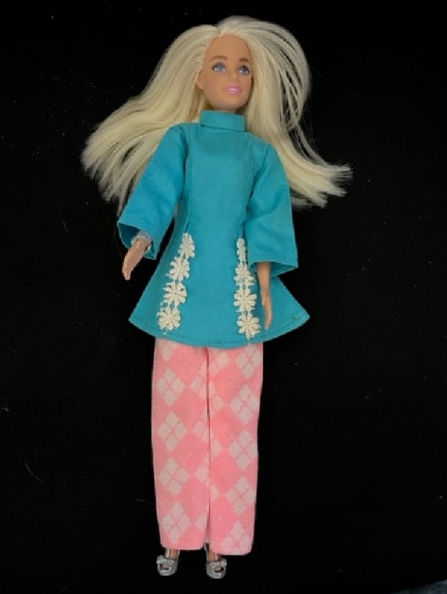 Photo: Barbie in blue and pink clothes made by the author’s mother and grandmother. Credit: Gena Philibert-Ortega.