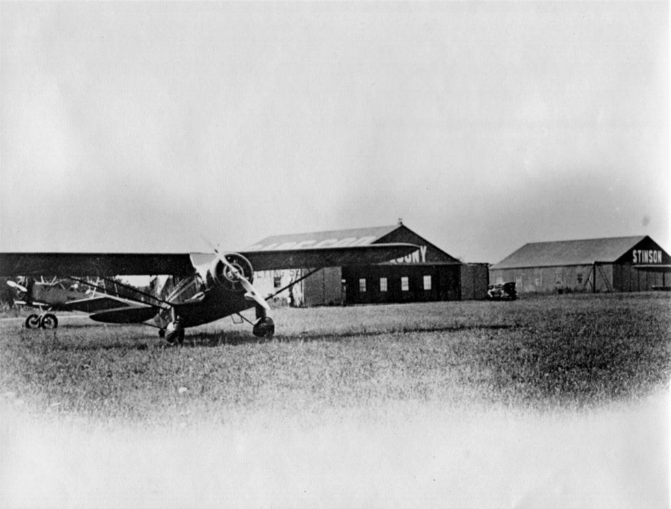 Photo: a Stinson airplane rests in front of the two hangars built by Zenas Crocker on the west side of Cape Cod Airfield about 1930 for Skyways Summer Flying School, run by Crocker Snow. Courtesy of Marston Mills Historical Society Collection; Digital Commonwealth.