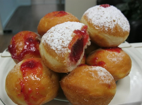 Photo: classic Hanukkah sufganiyot filled with strawberry jelly and powdered sugar. Credit: Noam Furer; Wikimedia Commons.