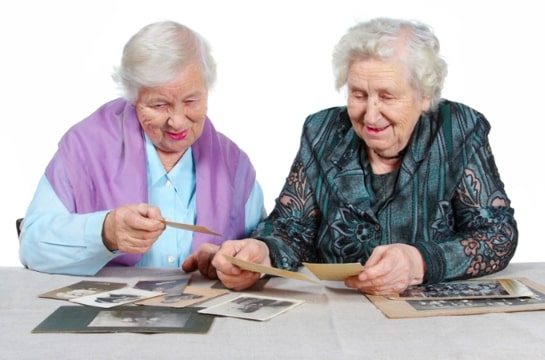 Photo: two elderly women looking at photos. Credit: https://depositphotos.com/home.html