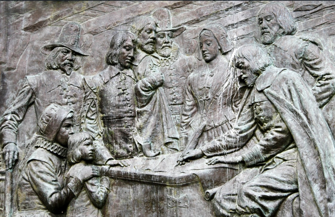 Photo: memorial bas relief of the signing of the Mayflower Compact, located on Bradford Street in Provincetown, Massachusetts, below the Pilgrim Monument. Credit: World History Encyclopedia.