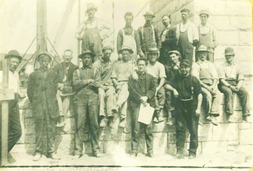 Photo: workmen gathered on the stone base of the Pilgrim Monument, taken by John R. Smith. Credit: Provincetown History Project.