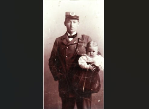 Photo: postal carrier with baby in mail bag. Credit: Smithsonian National Postal Museum.