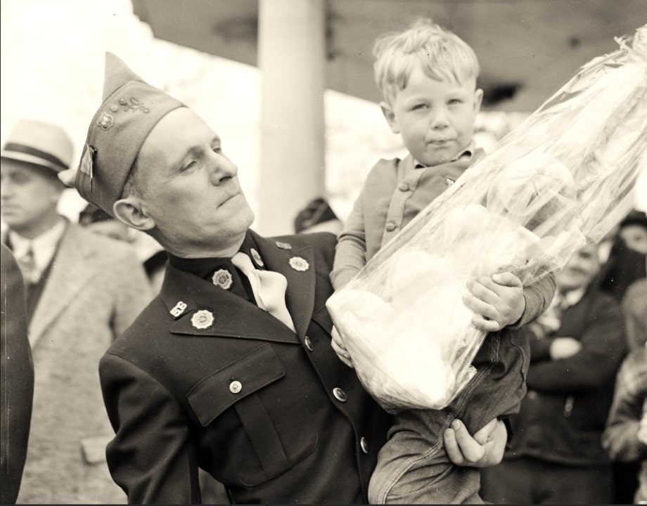 Photo: Legionnaire Clarence Hensel holding the winner of the rabbit Easter basket, Delmar Clark, 1939. Credit: McLean County Museum of History: Pantagraph Negatives Collection (Illinois Digital Archives).